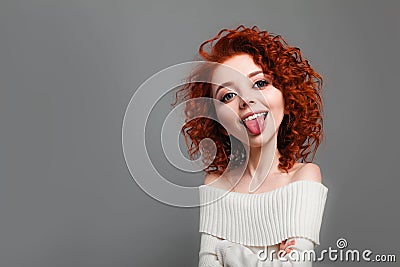 Funny red curly girl with big head shows tongue. Caricature stylization of female logic Stock Photo