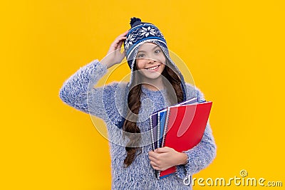 Funny school girl child student with book and warn hat, isolated yellow background. Learning and knowledge education Stock Photo