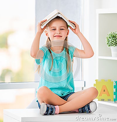 Funny schoolkid holding opened book Stock Photo