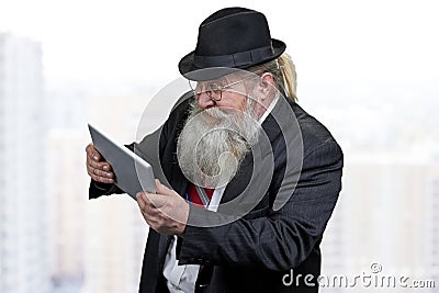 Funny senior businessman playing game on digital tablet pc. Stock Photo