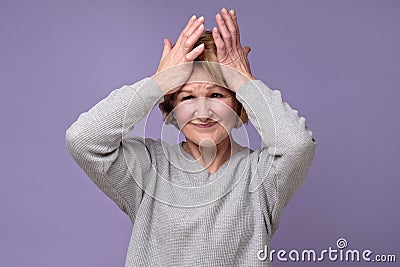 Funny senior caucasian woman remembered something and holds a hand on head Stock Photo