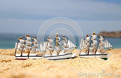 Funny small toy sailing ships on the beach Stock Photo