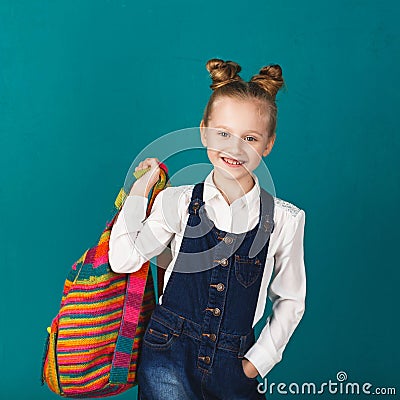 Funny smiling little girl with big backpack jumping and having f Stock Photo