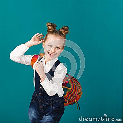 Funny smiling little girl with big backpack jumping and having f Stock Photo