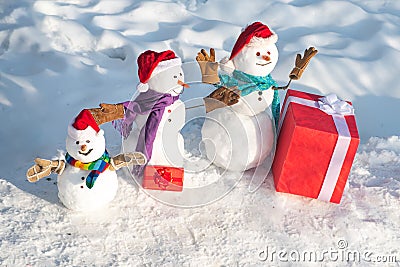 Funny snowmen family. Happy winter snowman family. Mother snow-woman, father snow-man and kid wishes merry Christmas and Stock Photo