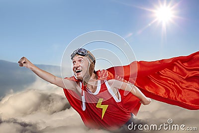 A funny super hero fly above the clouds in the sky Stock Photo