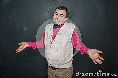 Funny teacher or business man in vintage style shrugging shoulders on blackboard Stock Photo