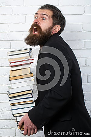 Funny teacher or professor with book stack. Thinking serious mature teacher. Falling books concept. Mature professor Stock Photo