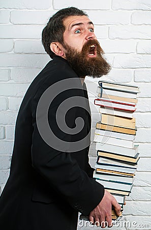 Funny teacher or professor with book stack. Thinking serious mature teacher. Falling books concept. Mature professor Stock Photo