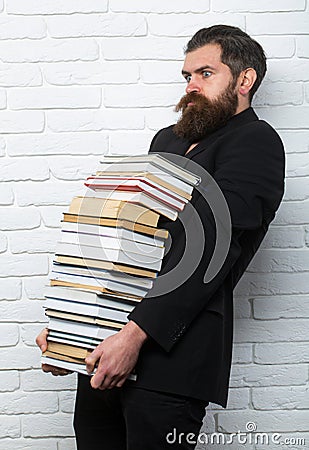 Funny teacher or professor with book stack. Thinking serious mature teacher. Falling books concept. Mature professor Stock Photo