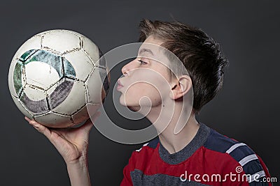 Funny teenage boy is kissing a soccer ball Stock Photo