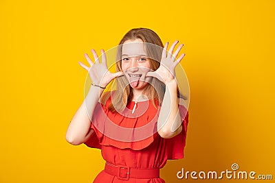 Funny teenage girl with braces on her teeth shows her tongue and has fun Stock Photo