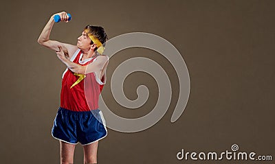 A funny, thin freak guy in sportswear with dumbbells showing musles Stock Photo