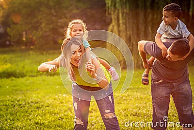 Funny time - Parents giving piggyback ride to children Stock Photo