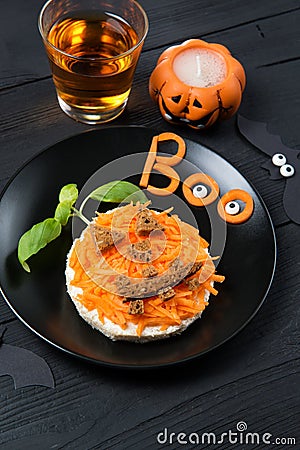 Funny toast with carrots in a shape of pumpkin, sandwich for kids Halloween idea, wooden background Stock Photo