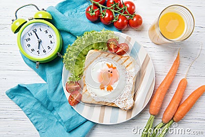 Funny toast with fried egg in a shape of chicken and alarm clock, food for kids Easter idea, top view Stock Photo
