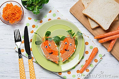 Funny toasts in a shape of carrots, food for kids Easter idea, top view Stock Photo