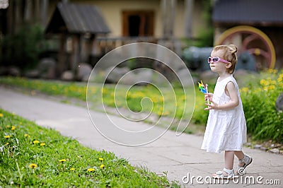 Funny toddler in sunglasses girl with a toy Stock Photo