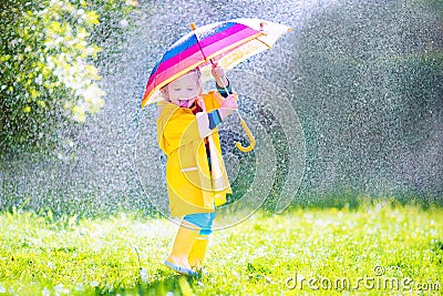 Funny toddler with umbrella playing in the rain Stock Photo