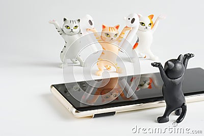 Funny toy cats advertise white wireless tws headphones next to mobile phones. copyspace. Photo Stock Photo