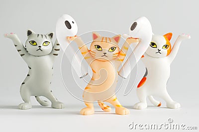 Funny toy cats advertise white wireless tws headphones. Unusual stand for tws headphones. Photo. Selective focus Stock Photo