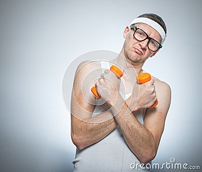 Funny weak man holding dumbbells Stock Photo