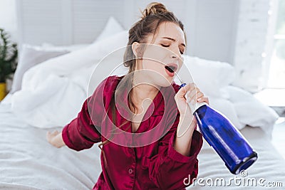 Charming funny woman singing holding bottle of wine Stock Photo