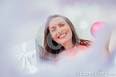 Funny woman looking childish and playful, holding pink bauble and present. Stock Photo