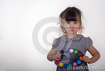 Funny 5 years old child holding palette of paints for drawing and paintbrush. Stock Photo