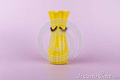 Funny yellow vase with eyes on a pink background Stock Photo