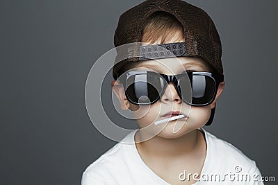 Funny Young Boy Eating A Lollipop.child in sunglasses Stock Photo