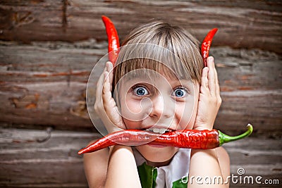 Girl with a red hot chili pepper in her mouth show devil horns Stock Photo