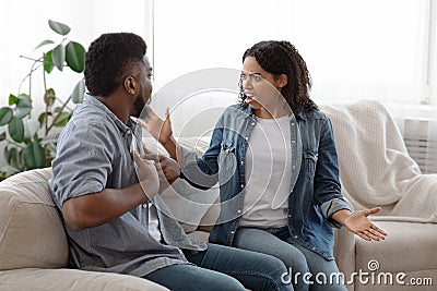 Furious African Woman Yelling At Her Boyfriend During Argue At Home Stock Photo
