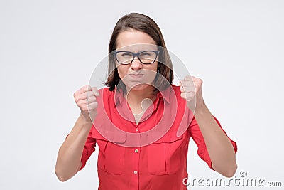 Furious and angry woman in glasses holding fist up Stock Photo
