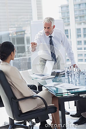 Furious boss pointing at an employee Stock Photo