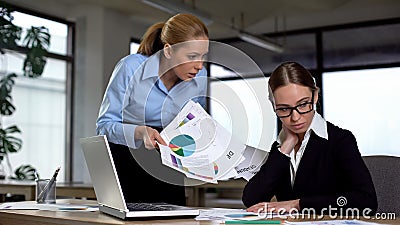 Furious boss scolding incompetent woman for bad results in financial report Stock Photo