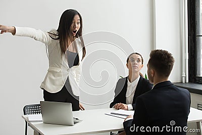 Furious businesswoman angry at businessman telling to leave mult Stock Photo