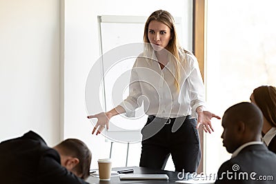 Furious businesswoman confused by employee dozing at briefing Stock Photo