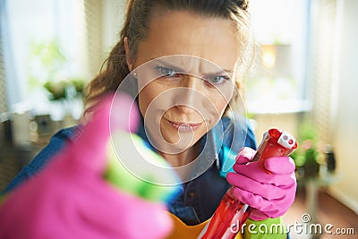 Furious female with cleaning agent threatening with finger Stock Photo