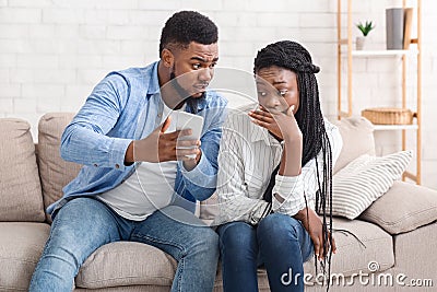 Furious Husband Catching Cheating Wife Texting On Phone With Another Guy Stock Photo
