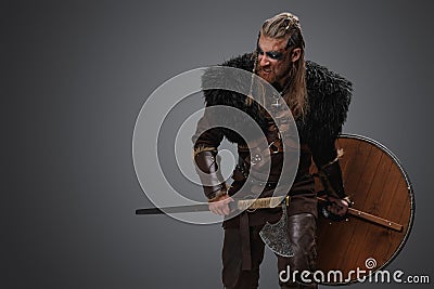 Furious viking from past holding shield and hatchet Stock Photo