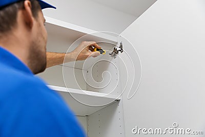 Furniture assembly service - worker installing cabinet doors Stock Photo