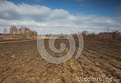 Furrows plowed field early in spring Stock Photo