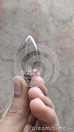 Small sharp glass light bulb in the hand Stock Photo