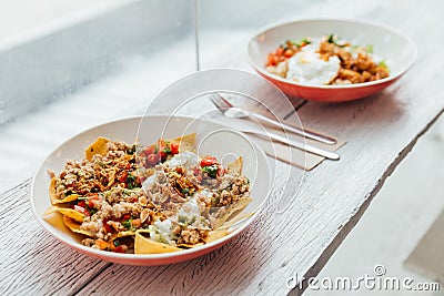 Fusion food Soboro Chicken Nachos: Japanese-style stir-fried chicken with tomato salsa, yogurt and Thai-style seafood sauce Stock Photo