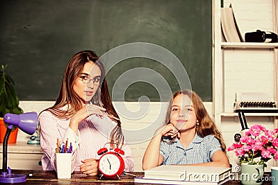 Future begins in school. Little girl and pretty woman back to school. Small child and teacher in school. School Stock Photo