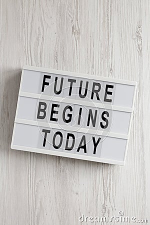 `Future begins today` words on a modern board on a white wooden surface, top view. Overhead, from above, flat lay Stock Photo