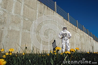 Futuristic astronaut in a helmet against gray walls. Fantastic Cosmic Costume. Stock Photo