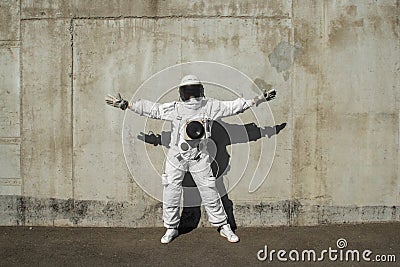 Futuristic astronaut in a helmet against gray walls. Fantastic Cosmic Costume. Stock Photo