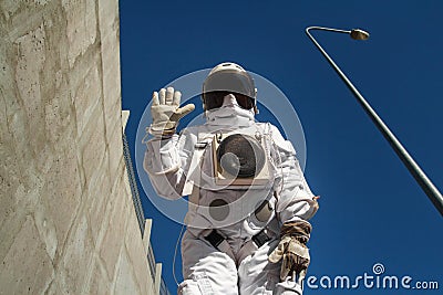 Futuristic astronaut in a helmet against gray walls. Fantastic Cosmic Costume Stock Photo